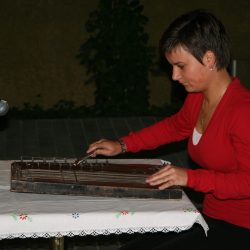 Veronika Zajec ob igranju na violinske citre. Izvirnik hrani Glasbenonarodopisni inštitut ZRC SAZU.