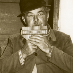 Franc Laporšek pri igranju na svoje trstenke leta 1991. Izvirnik hrani Glasbenonarodopisni inštitut ZRC SAZU.
